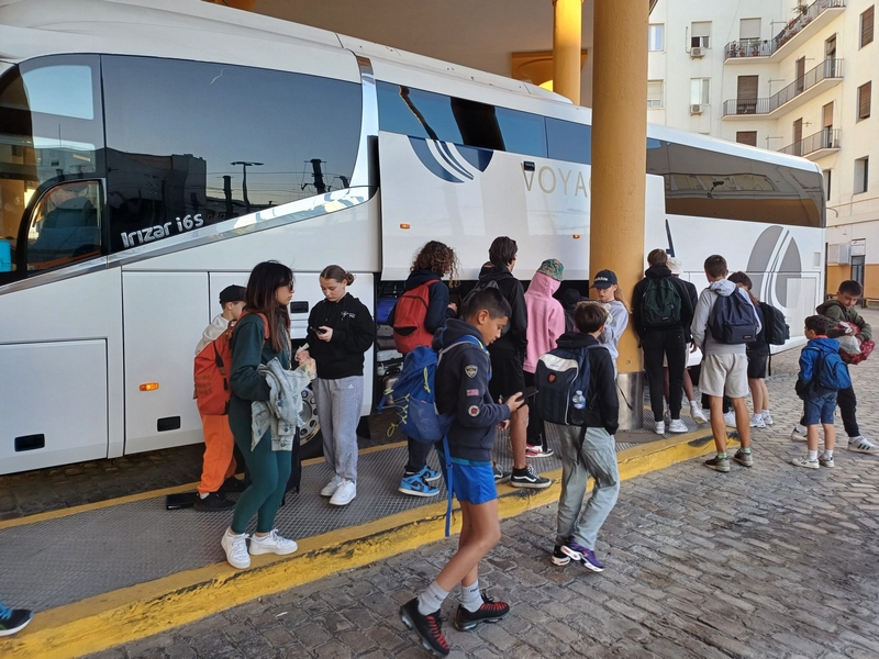 Responsable séjours scolaires assise à son bureau avec une mappe-monde dans la main